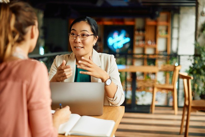 A female merchant services sales agent talks to a small business owner about payment solutions.